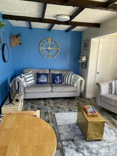 a living room with a couch and a clock on the wall at Bridlington chalet lodge 248 south shore holiday village with electric coin box in Bessingby