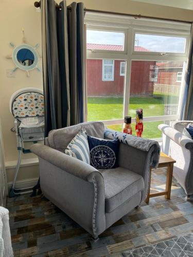 a living room with a couch and a window at Bridlington chalet lodge 248 south shore holiday village with electric coin box in Bessingby