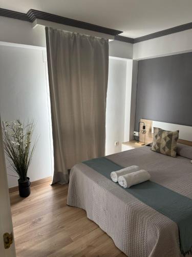 Un dormitorio con una cama con dos toallas encima. en Ámplio piso en el corazón de Torremolinos, en Torremolinos