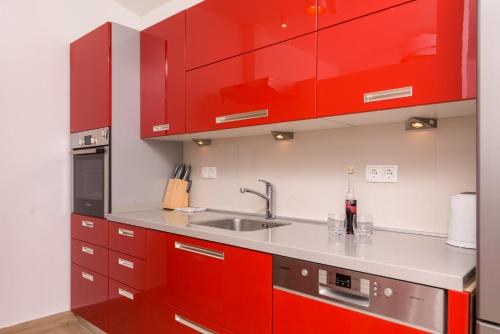 a kitchen with red cabinets and a sink at Paradise found in Komiža