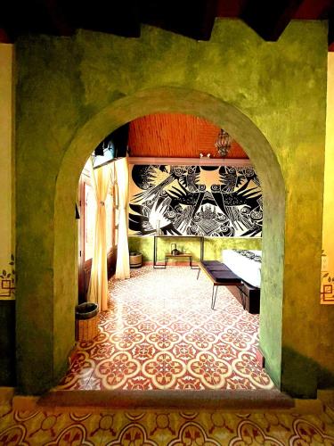 a room with an archway with a bed and a table at Hotel Boutique Santo Cuervo in Bernal