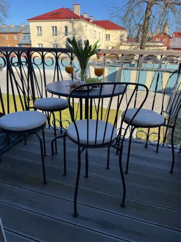 a table and chairs with wine glasses on a balcony at Bürgermeistri majutus in Haapsalu