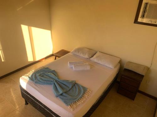 a bedroom with a bed with a blue blanket on it at Casa 6 Mares de Búzios - 5 minutos a pé da Rua das Pedras in Búzios