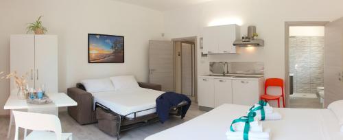 a small room with a bed and a kitchen at Rest House The Village in Nardò