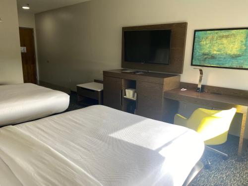 a hotel room with two beds and a flat screen tv at Comfort Inn & Suites Near Lake Guntersville in Scottsboro