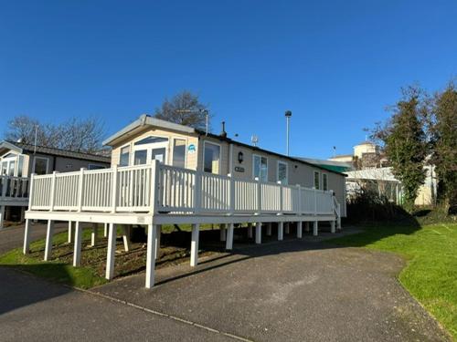 a house with a large white deck in front of it at 15 Ivy Close, 3 Bedroom Caravan, Pet Friendly in Budleigh Salterton