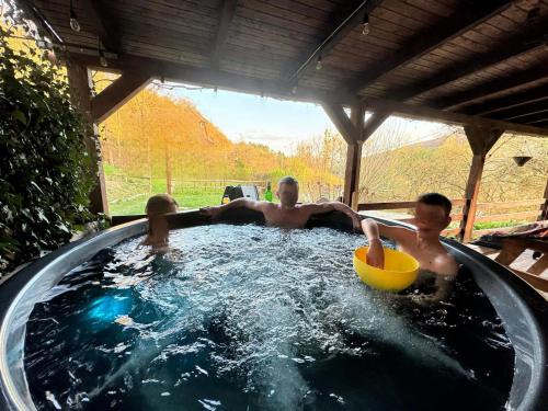 a group of three men in a hot tub at Parkside Vila in Odorheiu Secuiesc