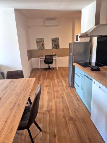 Il comprend une cuisine avec une table en bois et du parquet. dans l'établissement Spacieux T3, Résidence Charles Trenet, à Narbonne