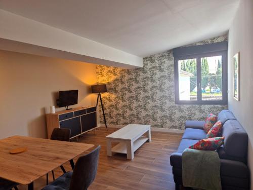 un salon avec un canapé bleu et une table dans l'établissement Spacieux T3, Résidence Charles Trenet, à Narbonne