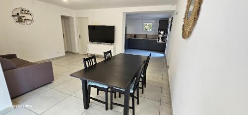 une salle à manger et un salon avec une table et des chaises dans l'établissement Bas de villa, à Cavalaire-sur-Mer