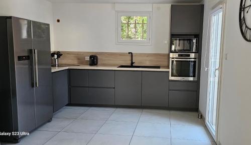 une cuisine avec un évier et un réfrigérateur dans l'établissement Bas de villa, à Cavalaire-sur-Mer