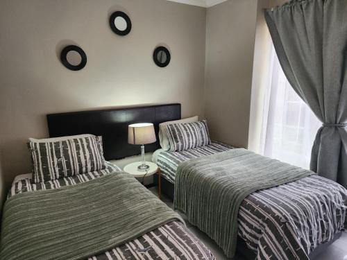 a bedroom with two beds and a window at Olympia in Pretoria