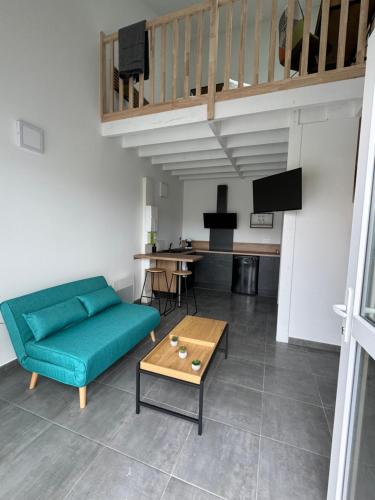 un salon avec un canapé vert et une table dans l'établissement Nathôme 3, à Aleçon