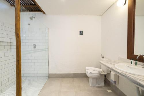a white bathroom with a toilet and a sink at Pousada Cheiro Verde in Arraial d'Ajuda