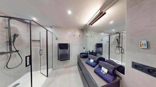 La salle de bains est pourvue d'une douche et d'oreillers bleus. dans l'établissement Le Majestic, Naturist Village 3 bedrooms 90 m2, au Cap d'Agde