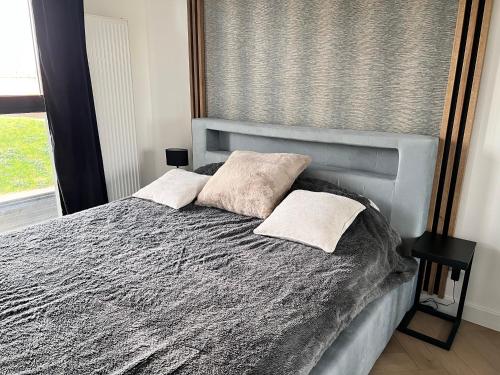 łóżko z dwiema poduszkami w sypialni w obiekcie Apartament Pierwsza Dzielnica w mieście Katowice