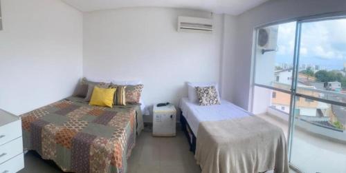 a bedroom with two beds and a balcony at Pousada Aliança in Salvador