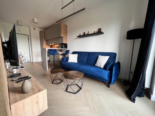 salon z niebieską kanapą i stołem w obiekcie Apartament Pierwsza Dzielnica w mieście Katowice