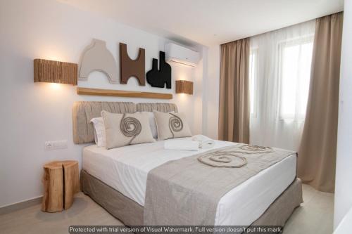 a bedroom with a large bed with white sheets at Joyful Tinos in Tinos Town
