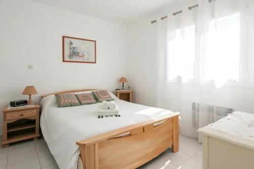 - une chambre blanche avec un grand lit et 2 tables dans l'établissement Appartement cosy dans résidence avec piscine et à 2 pas de la mer, à Bandol