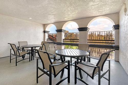a room with tables and chairs and a balcony at Best Western Plus Newport Mesa Inn in Costa Mesa