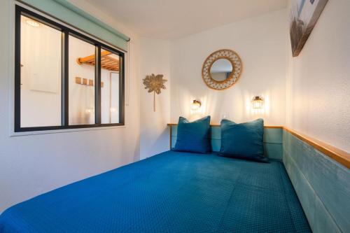 un canapé bleu dans une pièce avec une fenêtre dans l'établissement Résidence le Hameau de Cap Esterel - maeva Home - Appartement vue mer 2 pièces 4 personnes - Prestige - super Home MAE-1861, à Saint-Raphaël