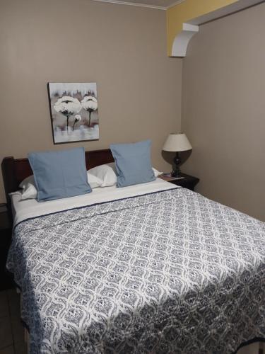 a bedroom with a large bed with blue pillows at Ultimate Freedom Bed and Breakfast in Santa Cruz