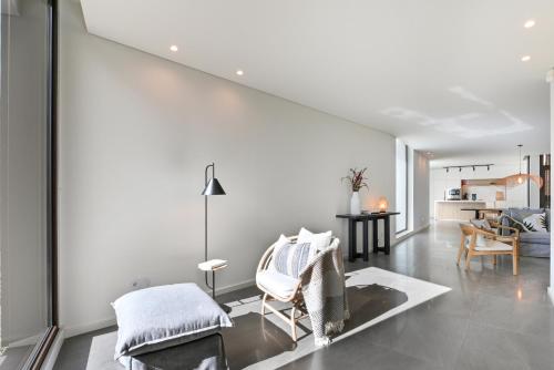 a living room with white walls and a table and chairs at Quinta Leitão with 25m Pool & Gim by Sé Apartamentos in Vieira do Minho