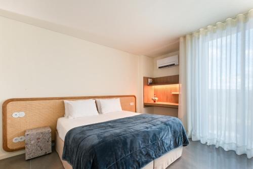 a bedroom with a bed and a large window at Quinta Leitão with 25m Pool & Gim by Sé Apartamentos in Vieira do Minho
