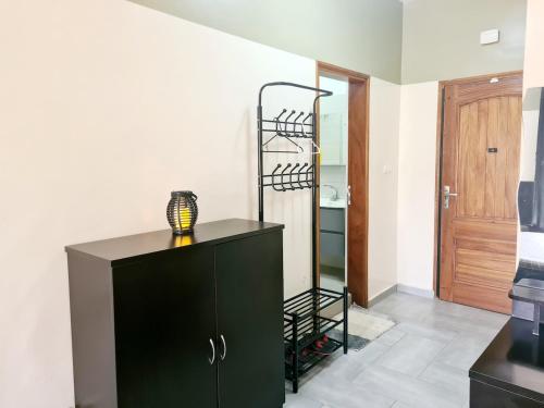 Un armario negro con una lámpara encima. en Charmant F1 avec Balcon - Wi-Fi & TV Connectée à Dakar, en Dakar