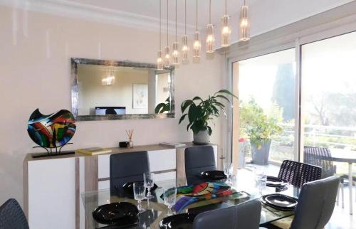 une salle à manger avec une table et un miroir dans l'établissement Appartement 6 personnes au cœur de Cannes - Appartement 4 pièces 6 personnes MAE-0031, à Cannes