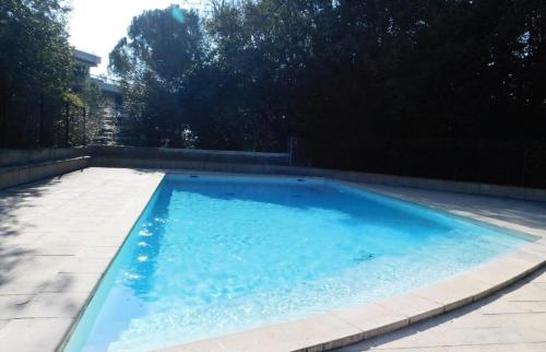 une grande piscine bleue dans une cour dans l'établissement Appartement 6 personnes au cœur de Cannes - Appartement 4 pièces 6 personnes MAE-0031, à Cannes