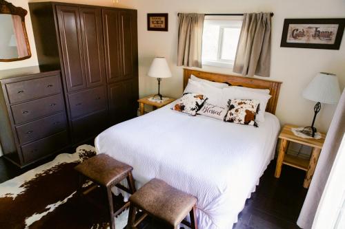 a bedroom with a large white bed and two chairs at A Wilderness Retreat - Your Gateway to Yellowstone in Cody