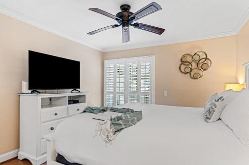 a bedroom with a white bed with a ceiling fan at Close to Beach w Patio Resort Amenities The Point at Corniche by AvantStay in Dana Point