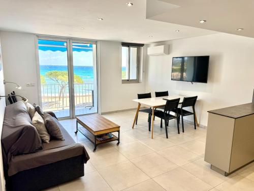 un salon avec un canapé et une table avec des chaises dans l'établissement T3 Panorama face mer 180 degrés parking inclus climatisation, à La Ciotat