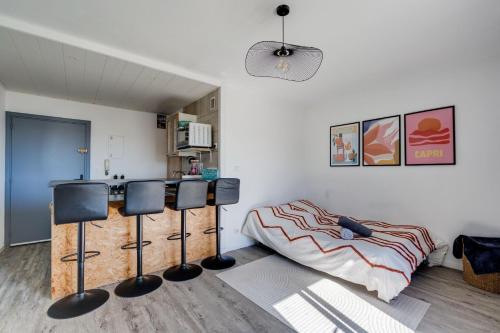 Cette chambre comprend un lit et des chaises. dans l'établissement Chez Dorian - Parking & Balcon, à Toulouse