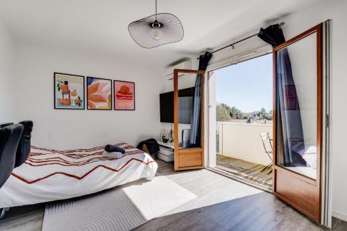une chambre avec un lit et une porte coulissante en verre dans l'établissement Chez Dorian - Parking & Balcon, à Toulouse