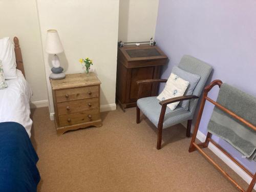 a bedroom with a bed and a chair and a dresser at Charlton Farm in Charlton