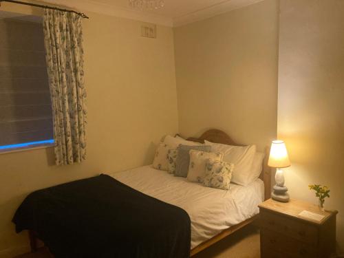 a bedroom with a white bed with a lamp and a window at Charlton Farm in Charlton