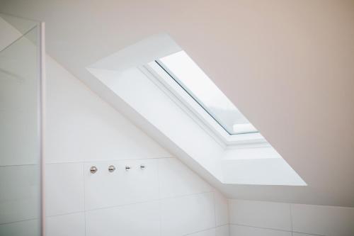 a bathroom with a skylight in the ceiling at HUGOS Design House am Waldrand - ruhig & modern in Bensheim