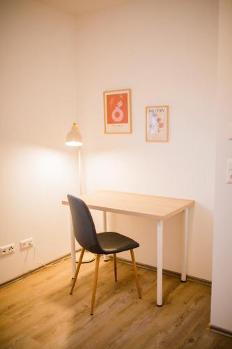 a desk with a chair and a lamp in a room at HUGOS Design House am Waldrand - ruhig & modern in Bensheim