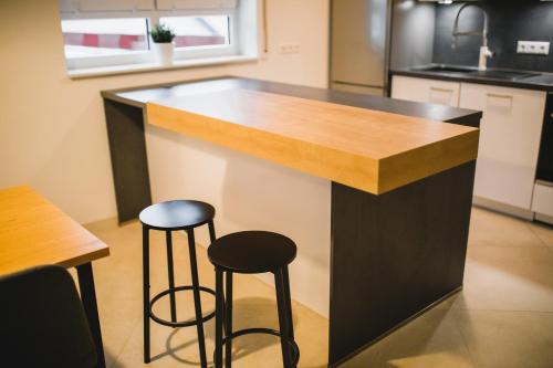 a bar in a kitchen with two stools at HUGOS Design House am Waldrand - ruhig & modern in Bensheim