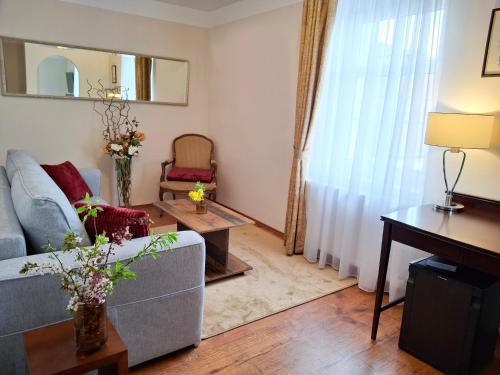 a living room with a couch and a table at Villa Patriot Apartmány in Mariánské Lázně