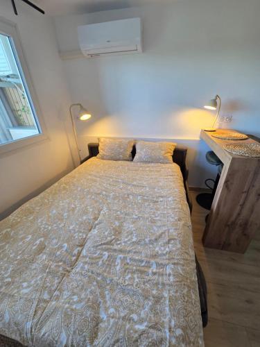 un lit dans une petite pièce avec une fenêtre dans l'établissement La tête dans les nuages, à Balaruc-les-Bains