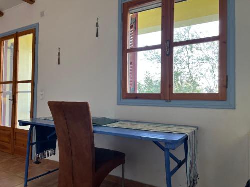 a blue desk with a chair and a window at Peaceful home amongst olive groves by the sea in Koroni