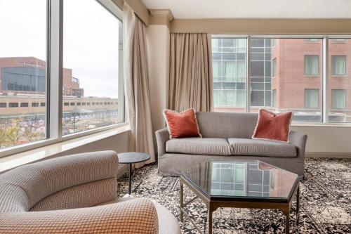 a living room with a couch and a table and windows at Omni Severin Hotel in Indianapolis