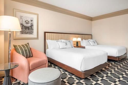 a hotel room with two beds and a chair at Omni Severin Hotel in Indianapolis