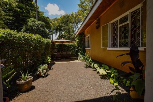 a pathway leading to a house with an umbrella at Utamaduni House B&B in Arusha