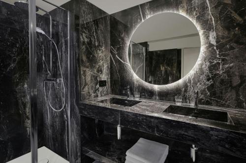 a bathroom with a sink and a mirror at Ghent Marriott Hotel in Ghent