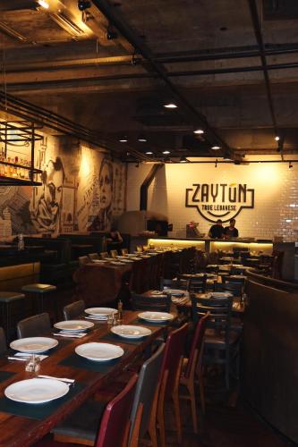 a restaurant with a long wooden table and chairs at Capcana Hotel Jardins in Sao Paulo